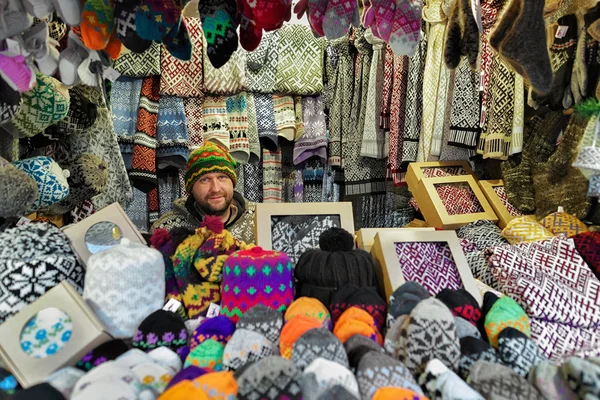 Smiling Man selling warm clothes at the Riga Christmas Market