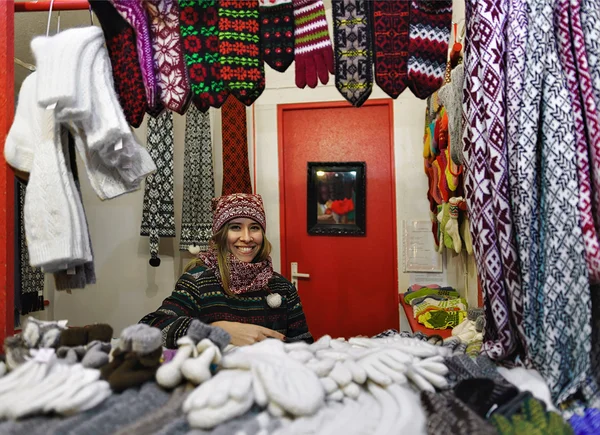 Smiling woman sells warm clothes in the Riga Christmas Market