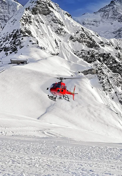 Red helicopter at swiss alps near Jungfrau mountain