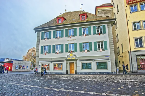 People passing by an elegant building at picturesque square Muhl