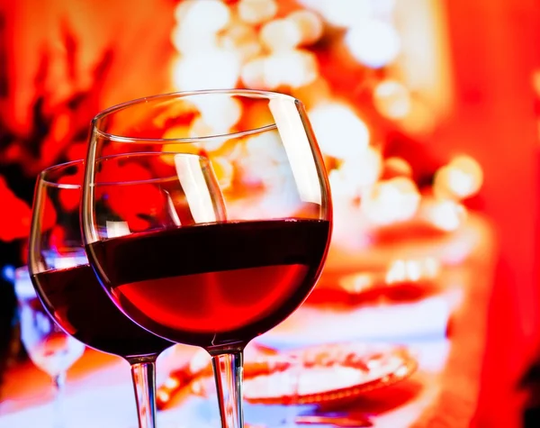 Two red wine glasses against restaurant table background