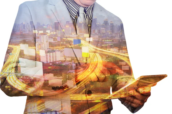 Double exposure of a businessman and a city using a tablet with