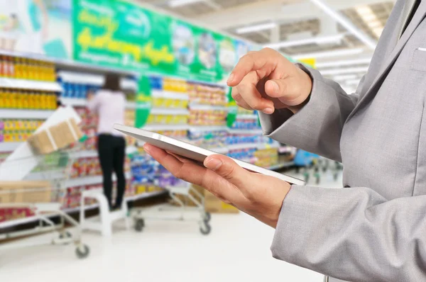 Hand of Businessman use Mobile Tablet in supermarket