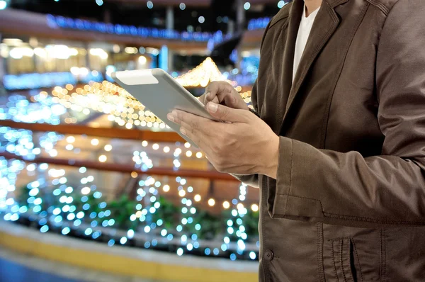 Young Man Hands holding Tablet or Mobile Device in Shopping Mall
