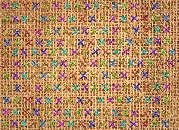 Close up of colorful cross stitch detail on designer cushion