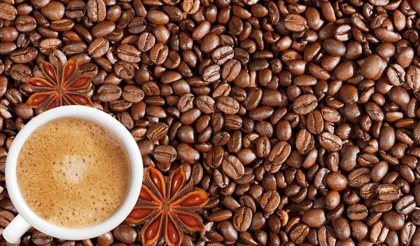 Close-up of coffee beans background and white coffee cup