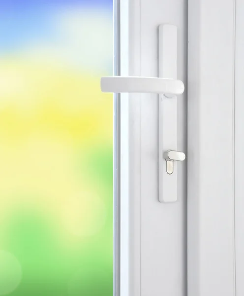 Plastic window with lock and bright blurred nature background
