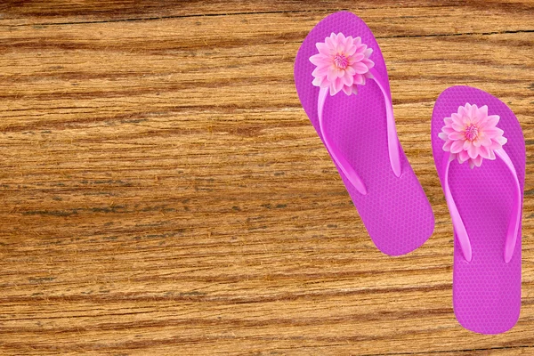 Pink beach shoes with flowers on wooden