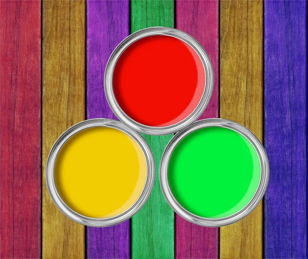 Open tin cans with paint on paint wooden background