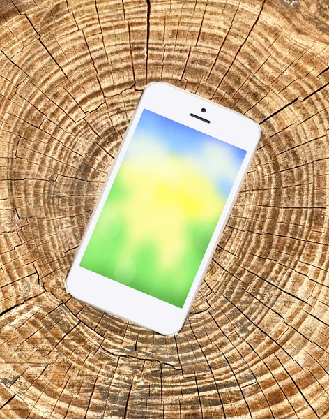 Mobile phone with bright screen on wooden cracked background