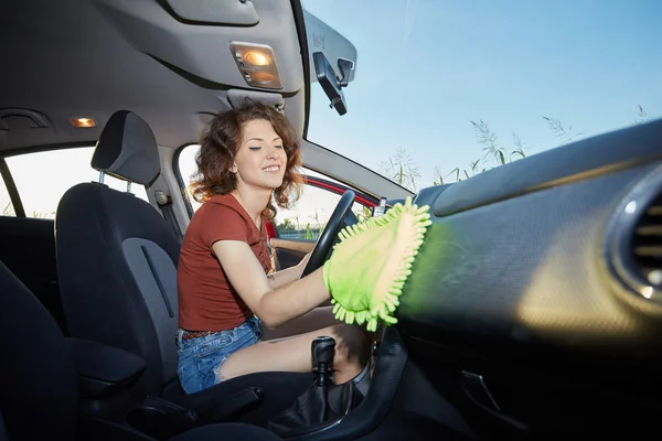 Woman with microfiber cloth cleaning car