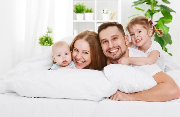 Happy family at home in  the bed