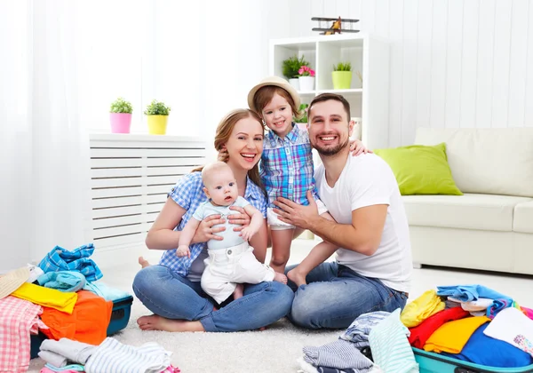 Happy family mother, father and two children packed suitcases fo