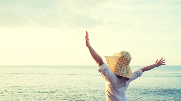 Happy woman standing arms outstretched back and enjoy life on be