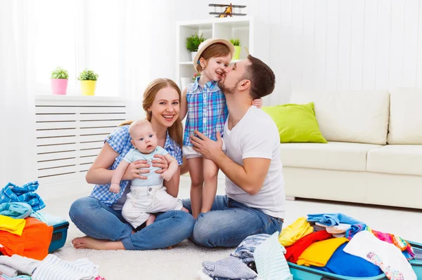 Happy family mother, father and two children packed suitcases fo