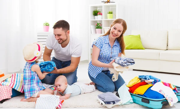 Happy family mother, father and two children packed suitcases fo