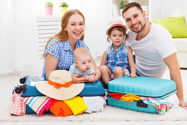 Happy family mother, father and two children packed suitcases fo