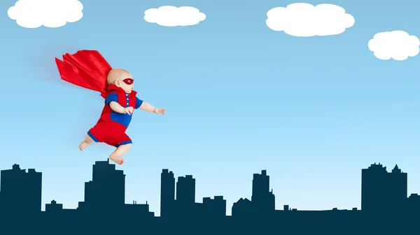 Toddler little baby superman superhero with red cape flying thro