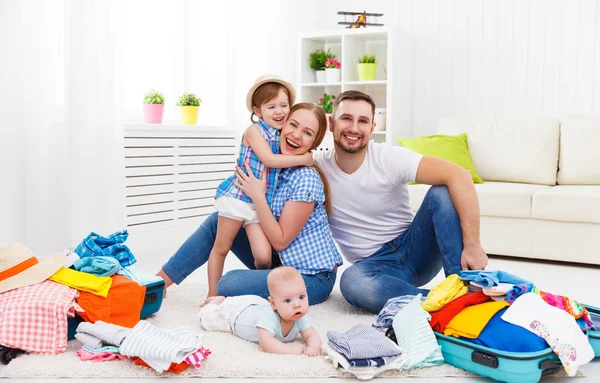 Happy family mother, father and two children packed suitcases fo