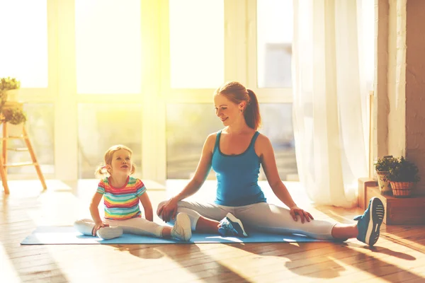 Family mother and child daughter are engaged in fitness, yoga at