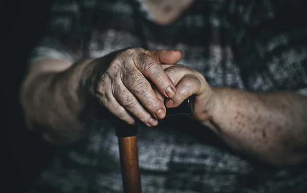 Hands of an old woman with a cane