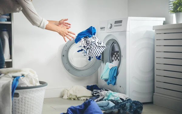Laundry concept. dirty clothes flies into washing machine