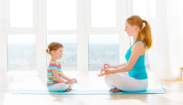 Family mother and child daughter are engaged in meditation and y