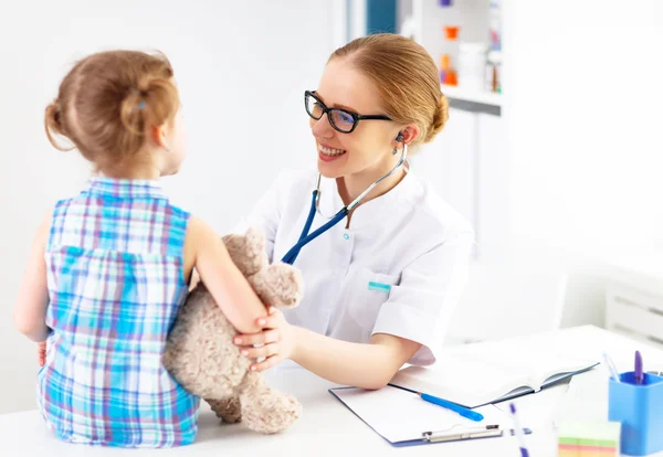 Friendly happy doctor pediatrician with patient child girl