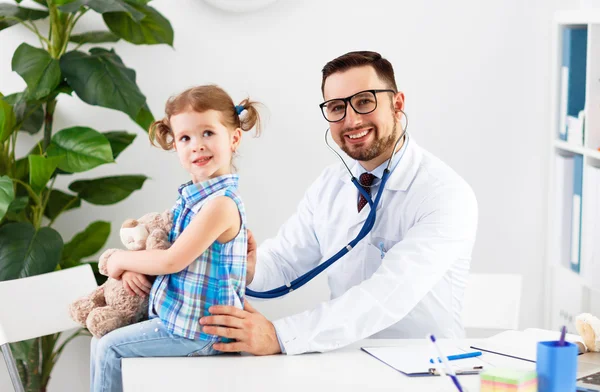 Friendly happy male doctor pediatrician with patient child girl