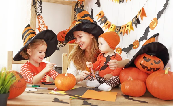 Family mother and children decorate home for Halloween