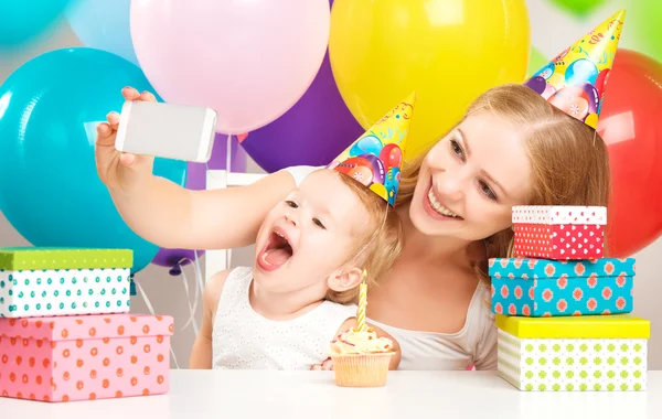 Happy children\'s birthday. selfie. mother photographed  her daughter the birthday child with balloons, cake, gifts