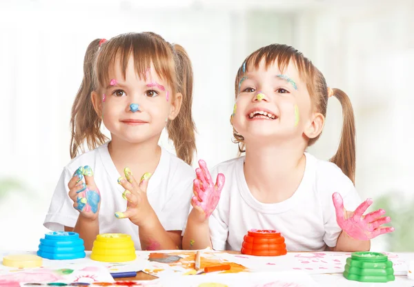 Happy children twins draws paints , get dirty