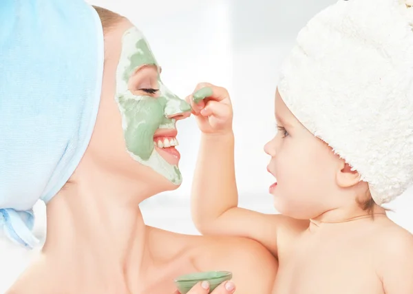 Family beauty treatment in  bathroom. mother and daughter baby girl make mask for face skin