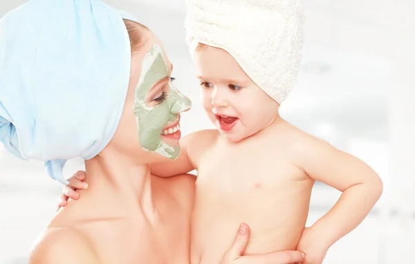 Family beauty treatment in bathroom. mother and daughter baby girl make mask for face skin