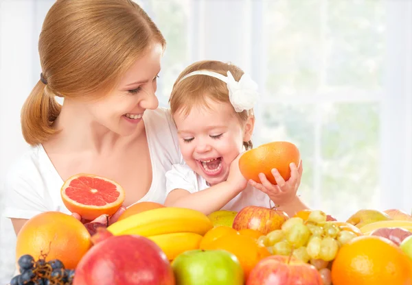 Happy family mother and daughter little girl, eat healthy vegetarian food, fruit