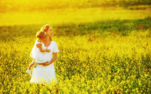 Happy family in summer meadow, mother and little daughter child