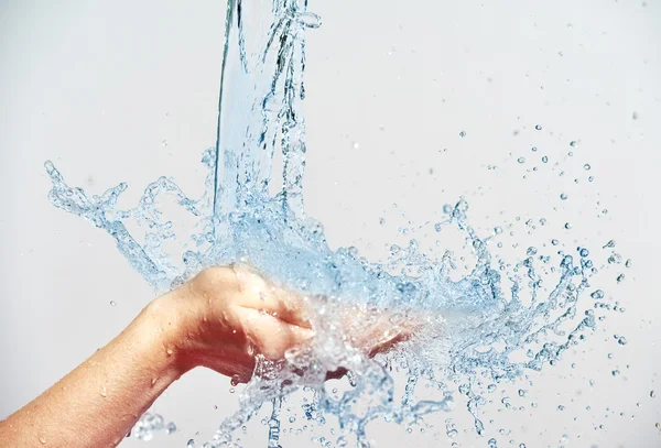 Woman hand with water splashes and drops