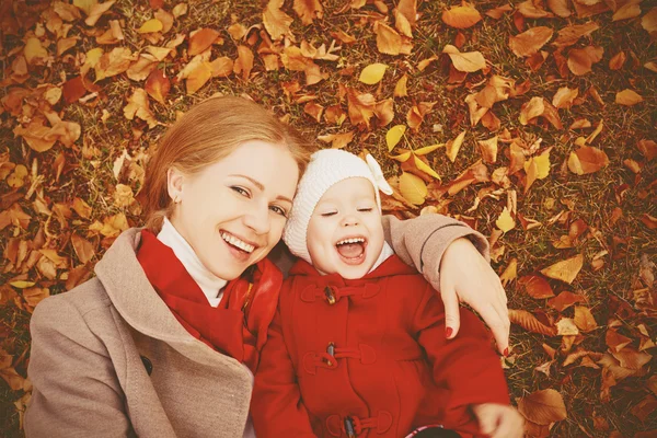 Happy family: mother and child little daughter play cuddling on