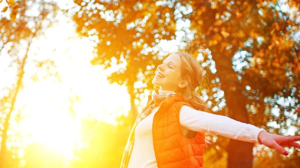 Happy girl enjoying life and freedom in autumn on nature