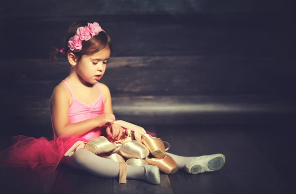 Little child ballerina with ballet pointe shoes and pink skirt t