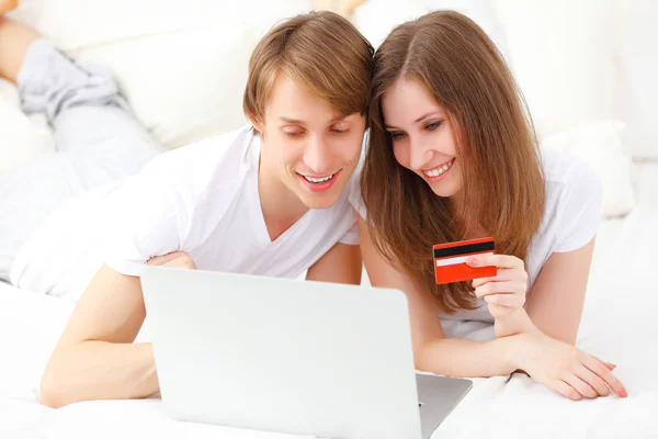 Happy couple makes online shopping with laptop and credit card a