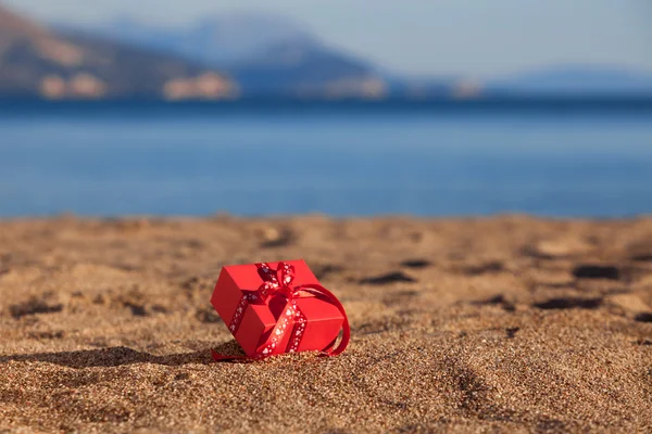 Red gift box on a beach
