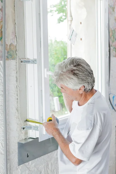 Mason measuring a window