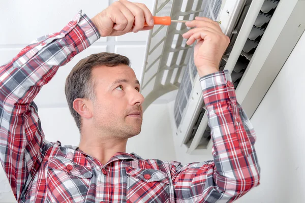 Man repairing air conditioning unit