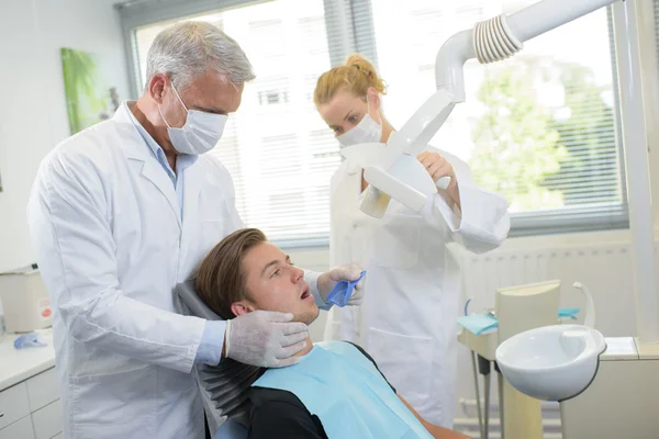 Dentist taking impressions of young man s teeth