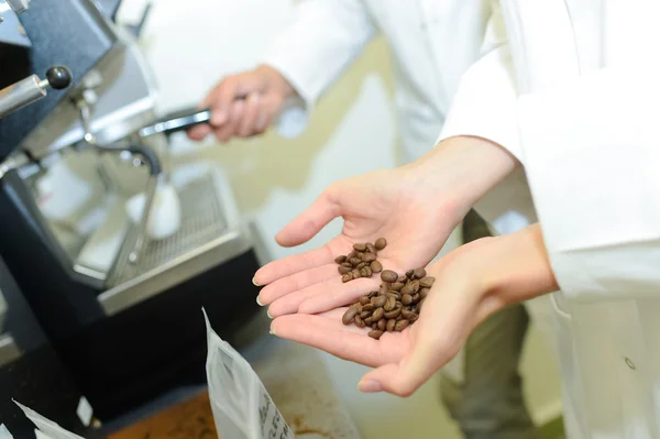Coffee beans held in palm of woman s hand
