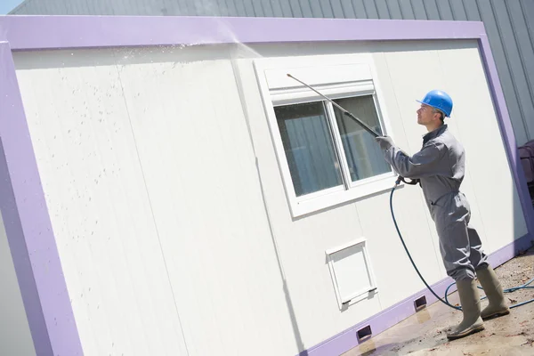 Man power washing building