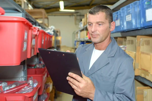 Man with clipboard in warehouse