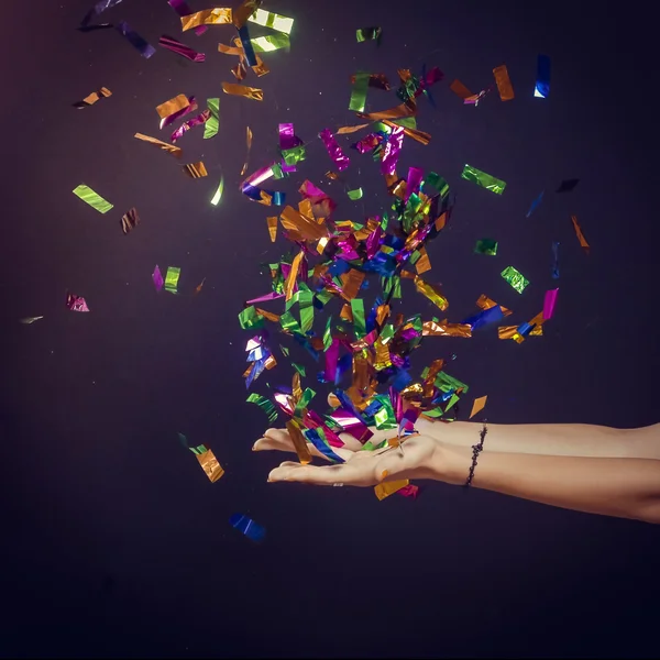 Party time - hands with lot of colorful confetti