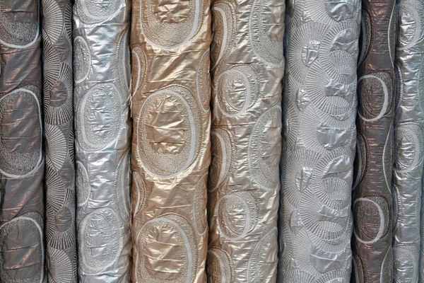 A variety of different bolts of brocade fabric